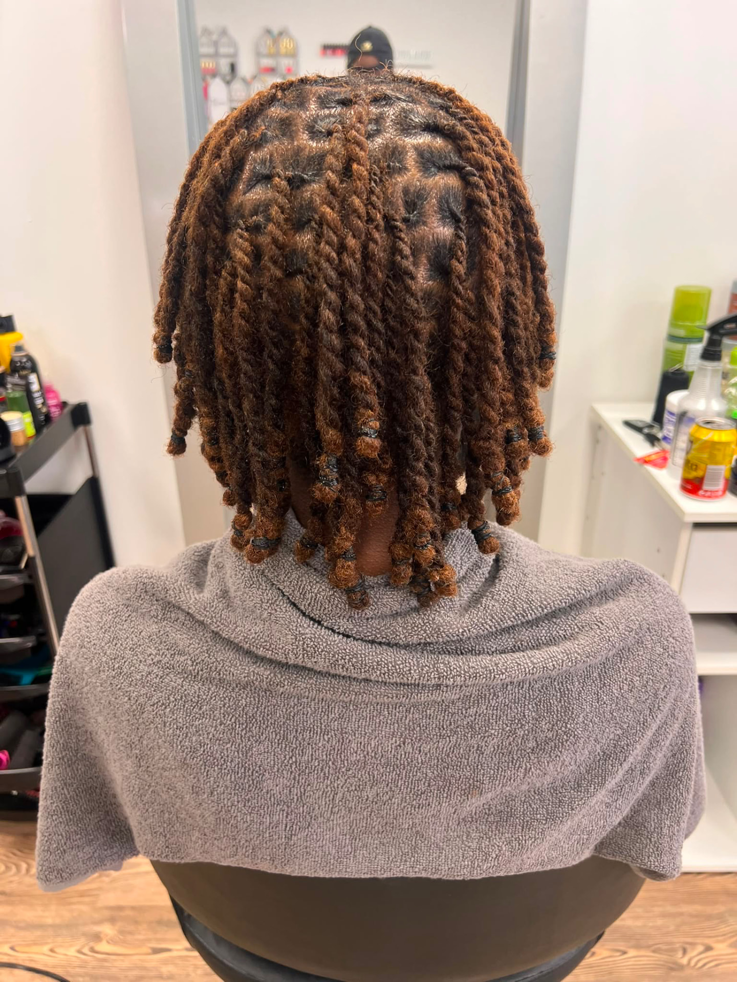 Back view of a finished auburn short loc retwist