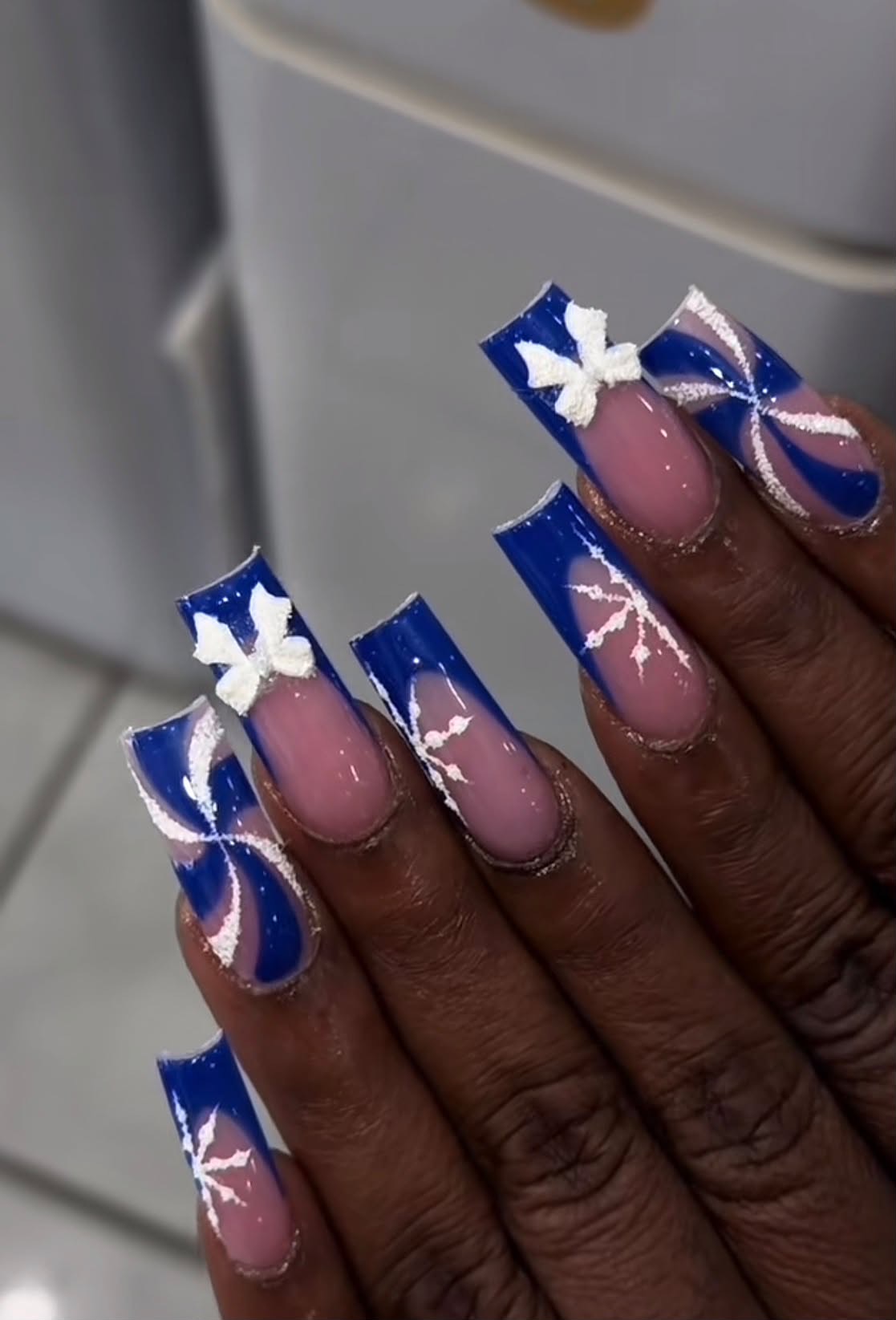 Blue French acrylic nails with white butterfly art